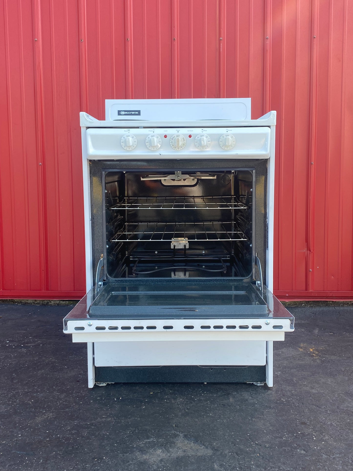 Open oven against a red wall