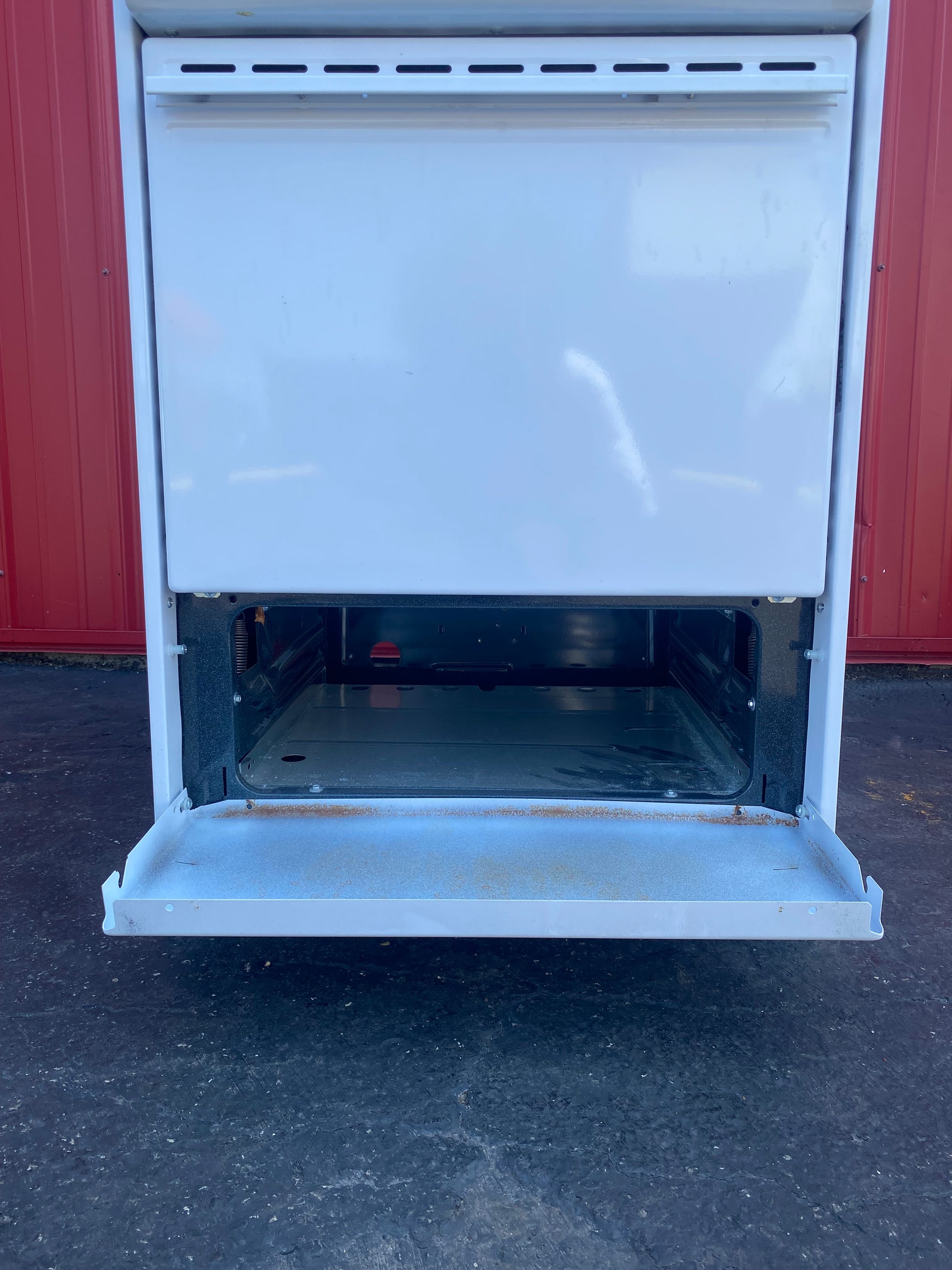 Open broiler against a red wall